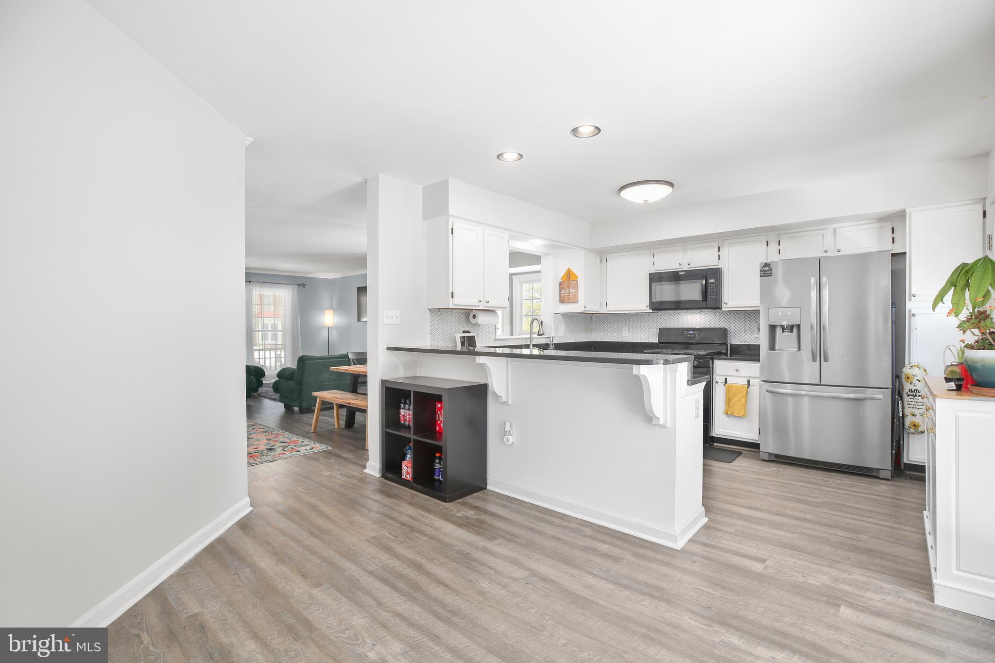 12385 Manchester Way Woodbridge, VA 22192 - Photo 8 of 32 a kitchen with stainless steel appliances a refrigerator a sink dishwasher a stove and white cabinets with wooden floor