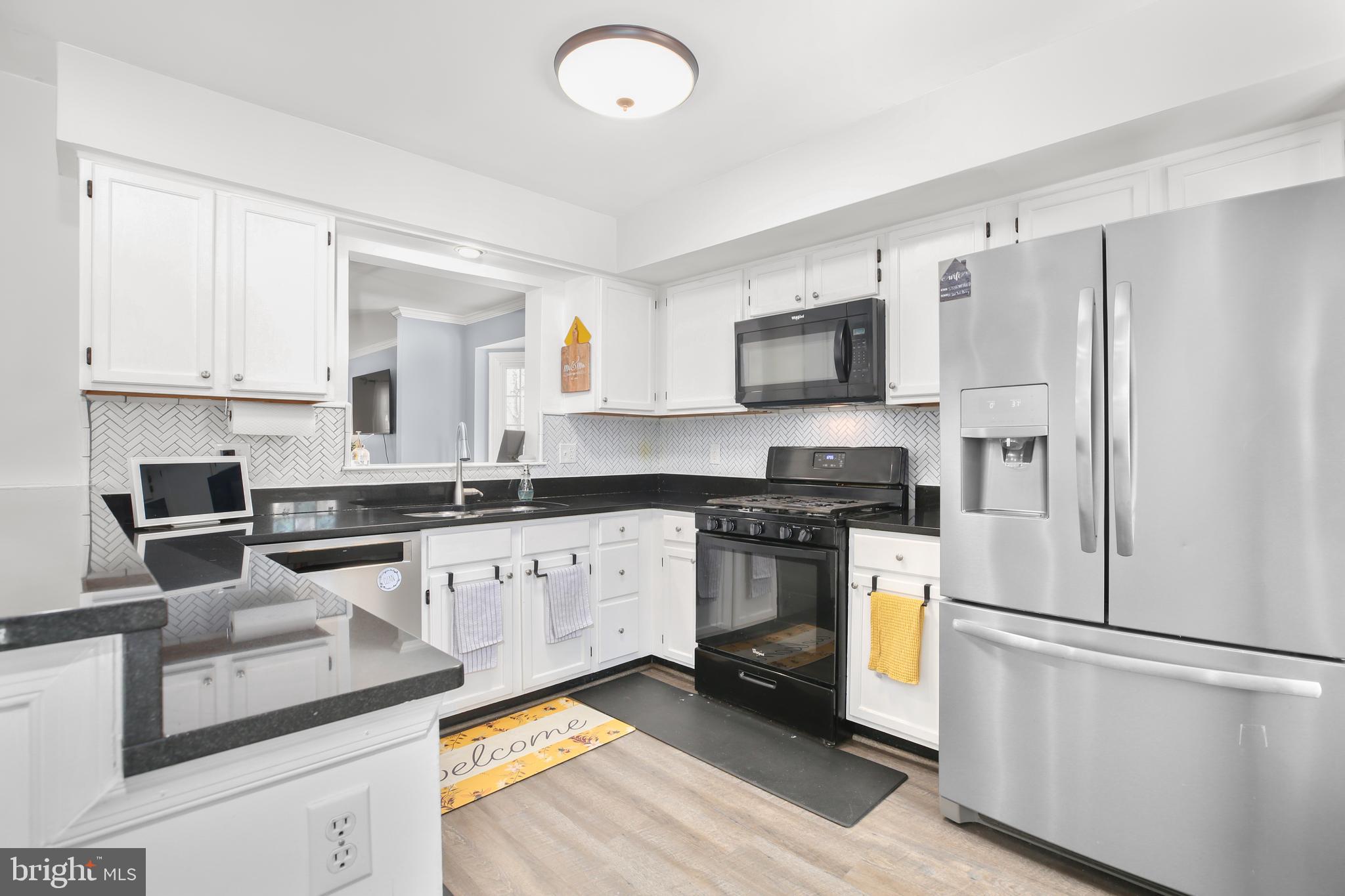 12385 Manchester Way Woodbridge, VA 22192 - Photo 9 of 32 a kitchen with granite countertop a refrigerator stove top oven and sink