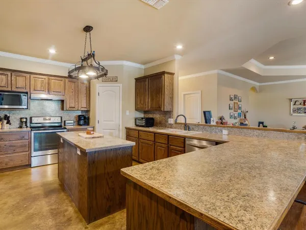a kitchen with stainless steel appliances granite countertop stove top oven and cabinets
