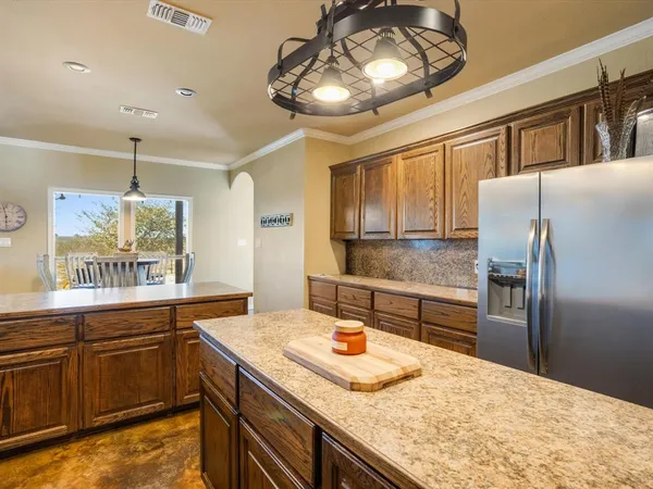 a kitchen with stainless steel appliances granite countertop a sink a stove and a wooden cabinets