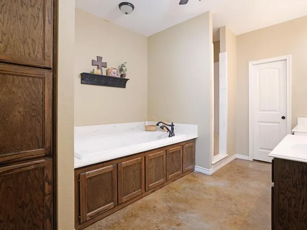 a bathroom with a tub sink and mirror