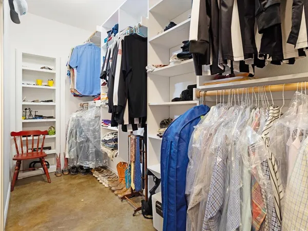 a view of walk in closet with clothes and shoes