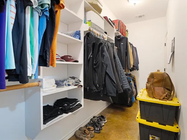 a view of walk in closet with clothes and shoes