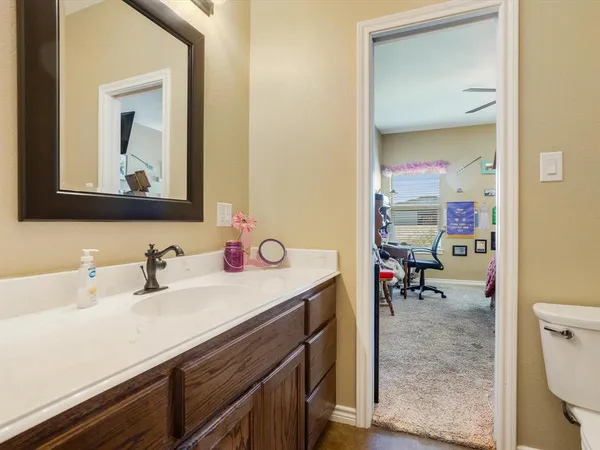 a bathroom with a sink a toilet and mirror