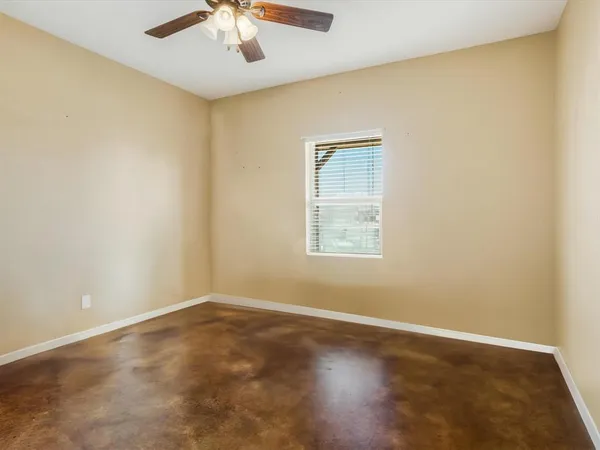 an empty room with a window and a ceiling fan