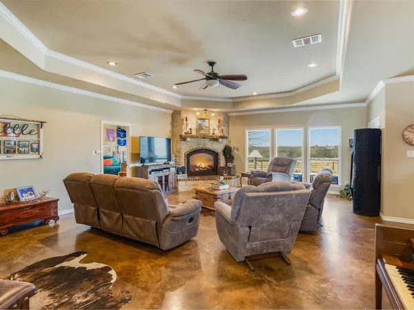 a living room with fireplace furniture and a large window