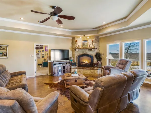 a living room with furniture a fireplace and a large window