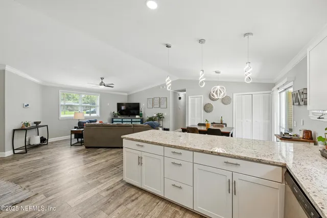 a large white kitchen with a large window
