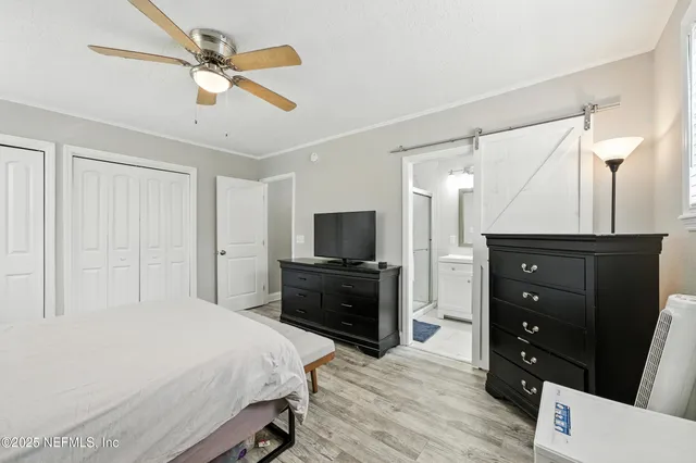 a bedroom with a bed and a flat tv screen on wall