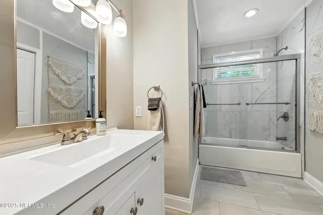a bathroom with a shower sink and mirror