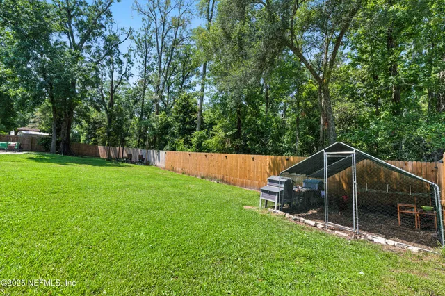 a view of house with backyard and trees