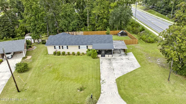 a aerial view of a house with swimming pool and large trees