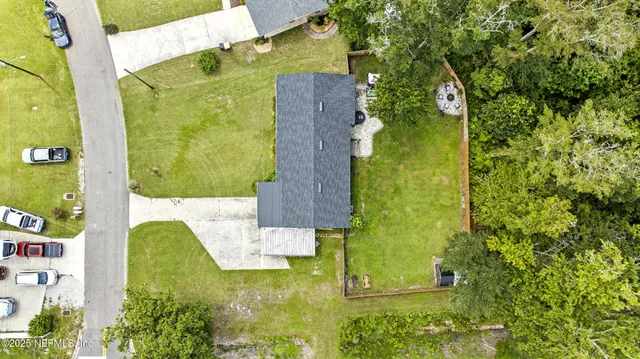 an aerial view of a residential houses with yard