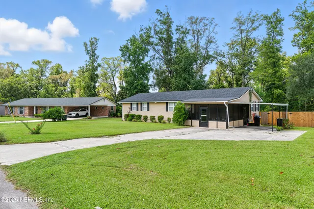 a front view of a house with a yard and trees