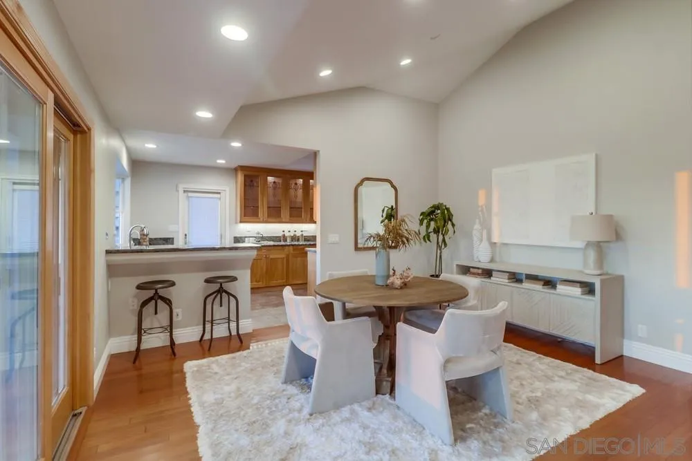 7970 Pasadena Avenue La Mesa, CA 91941 - Photo 7 of 38 a dining room with furniture a wooden floor and kitchen view