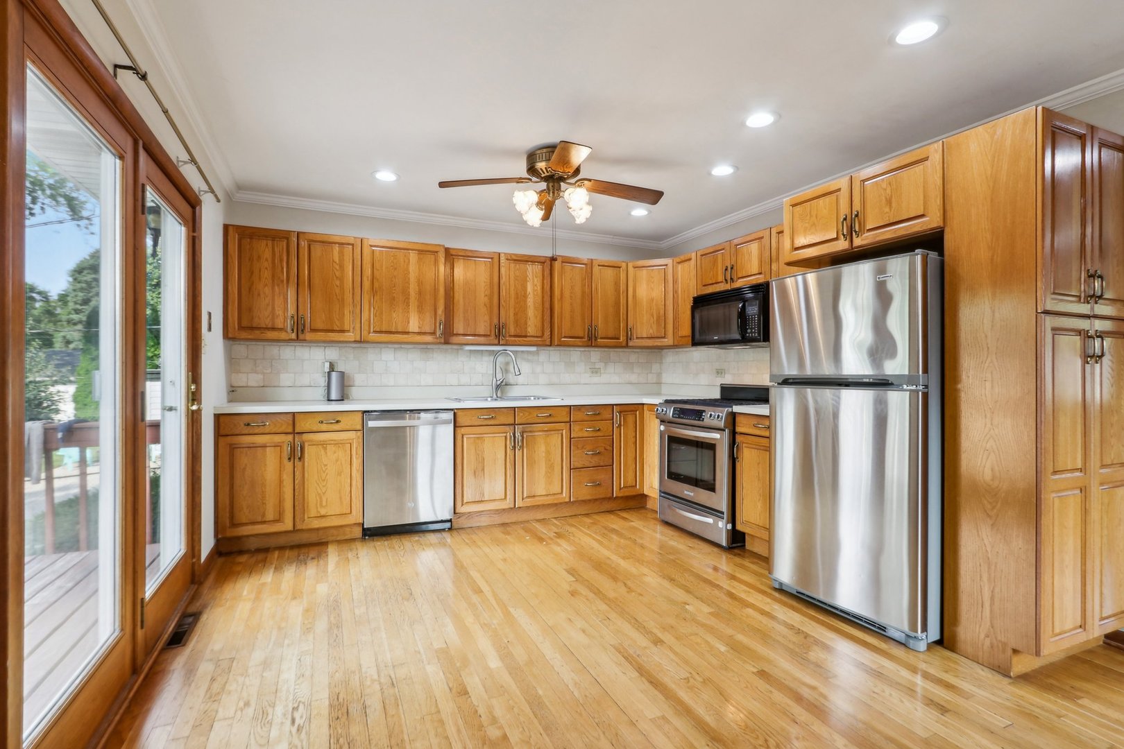 2405 Martin Lane Rolling Meadows, IL 60008 - Photo 8 of 22 a kitchen with a refrigerator a stove top oven a sink and dishwasher with wooden floor