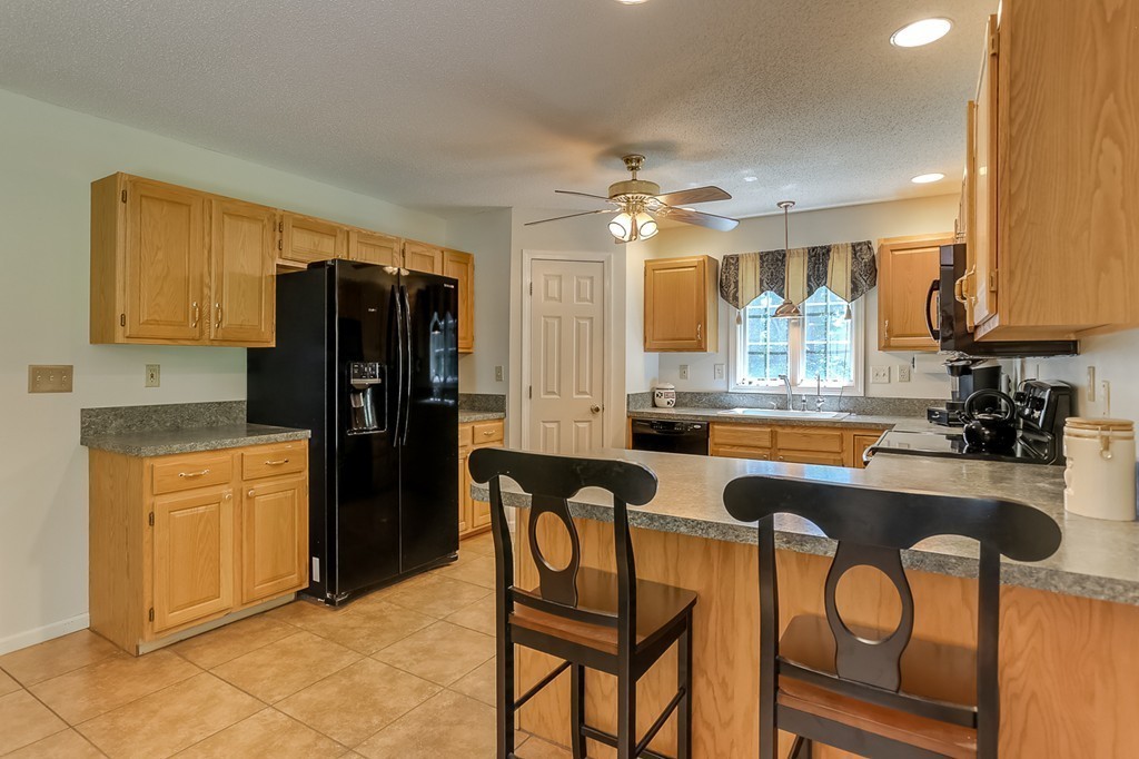 47 Babcock Tavern Road Ware, MA 01082 - Photo 6 of 27 a kitchen with a refrigerator a sink and chairs