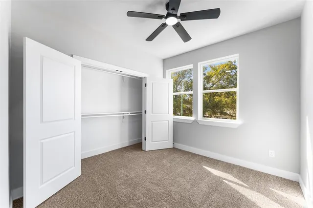 an empty room with a ceiling fan and a window