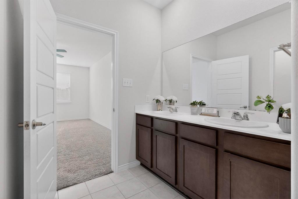 2917 Lampasas Lane Little Elm, TX 75068 - Photo 19 of 36 a bathroom with a double vanity sink a mirror and a shower