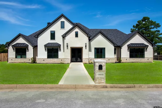 a front view of a house with a garden and yard