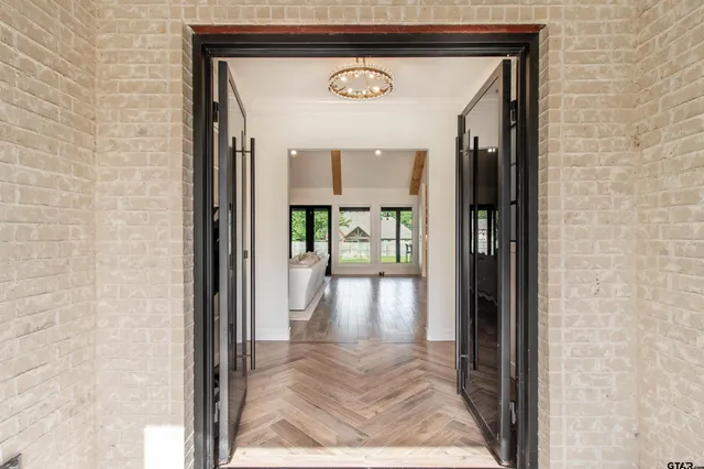 a view of a hallway with wooden floor and a glass door