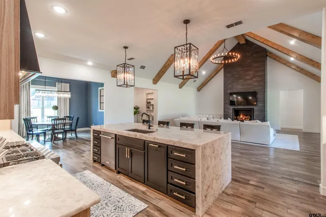 a kitchen with stainless steel appliances granite countertop a stove and a wooden floors