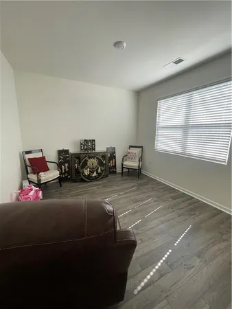 an empty room with wooden floor and a bathroom