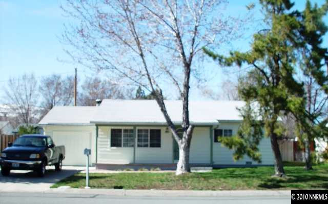 a front view of a house with a garden and trees