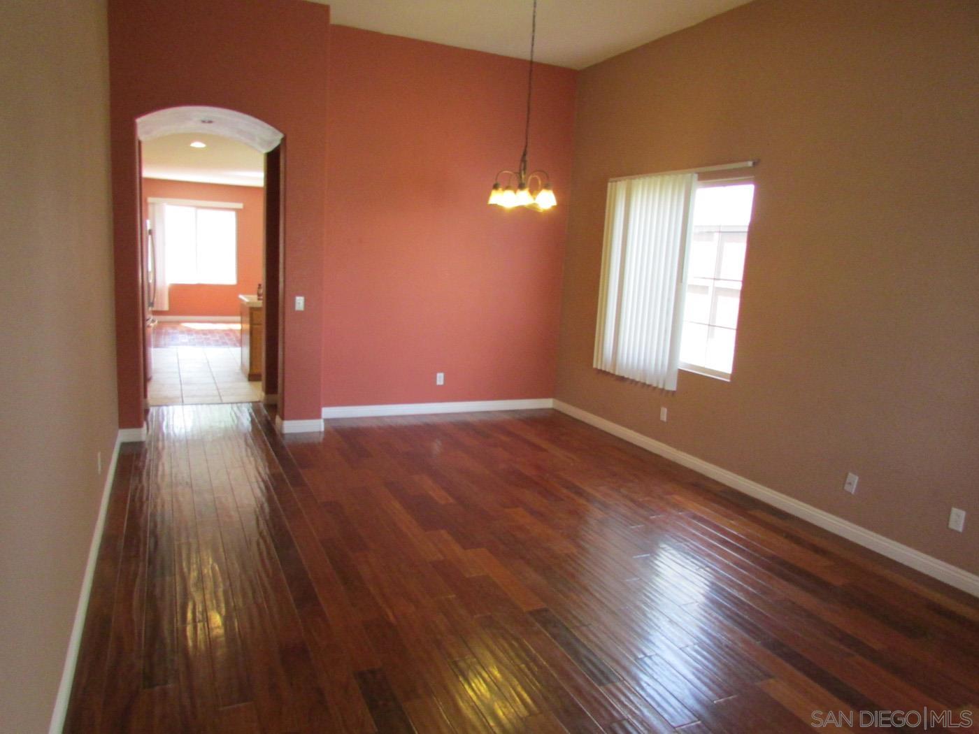 757 Aldea Drive Oceanside, CA 92057 - Photo 2 of 11 an empty room with wooden floor and windows