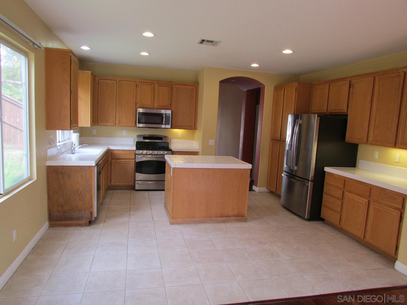 757 Aldea Drive Oceanside, CA 92057 - Photo 3 of 11 a kitchen with stainless steel appliances granite countertop a refrigerator stove and sink