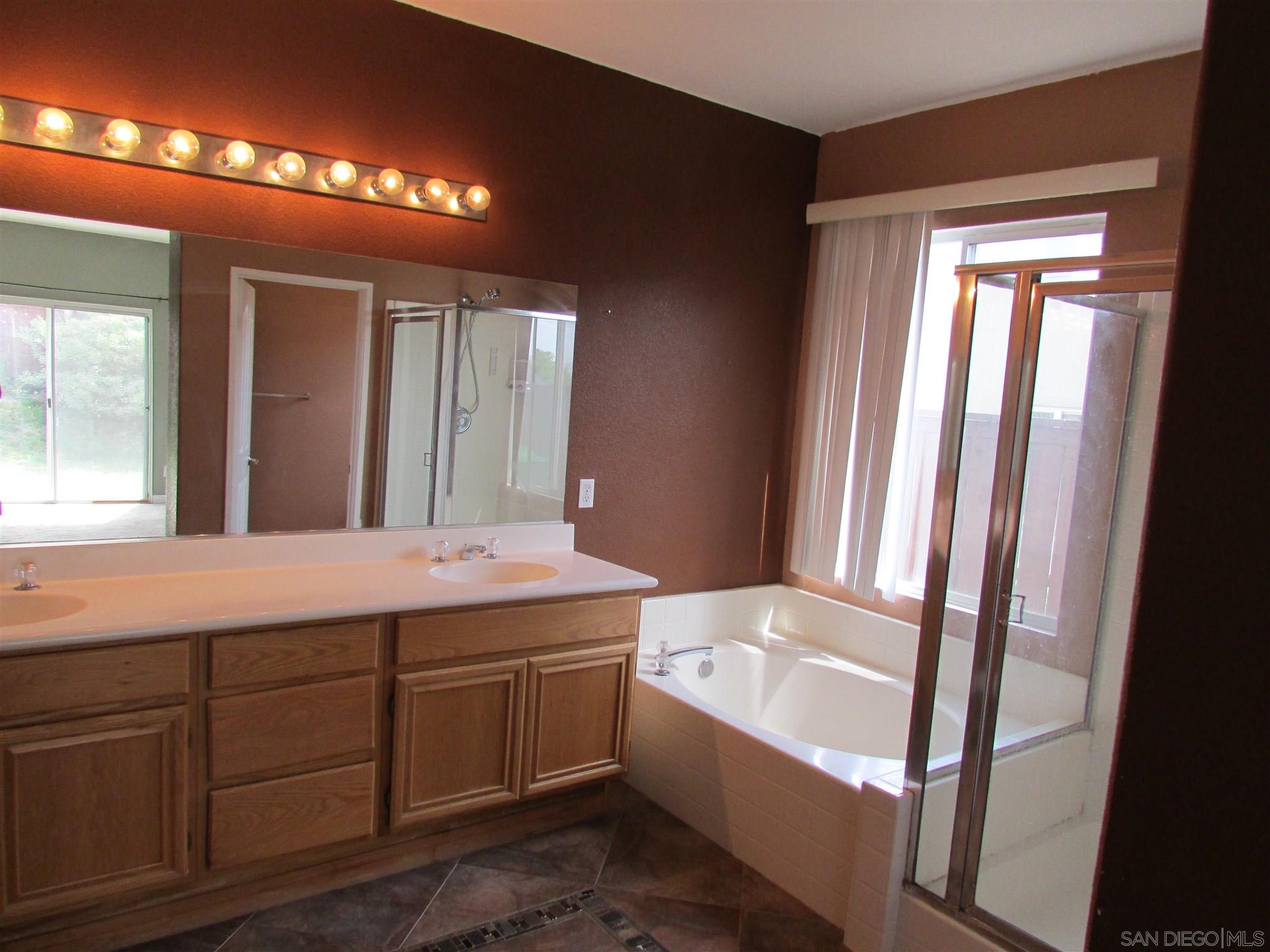 757 Aldea Drive Oceanside, CA 92057 - Photo 8 of 11 a bathroom with a sink mirror and a bathtub