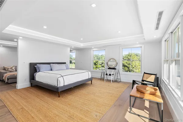 a bedroom with a bed and large windows