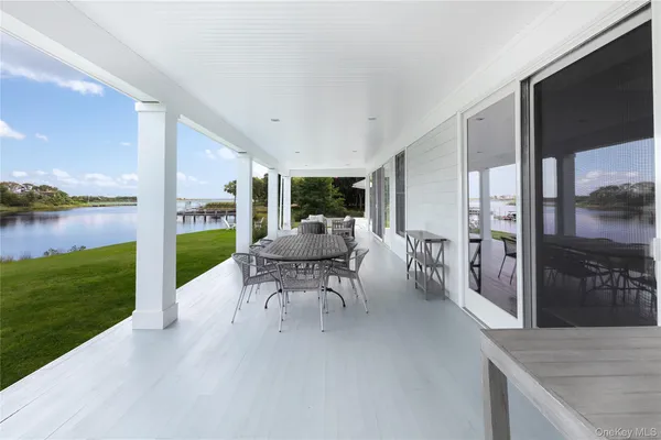 a patio with table and chairs and couches with wooden floor