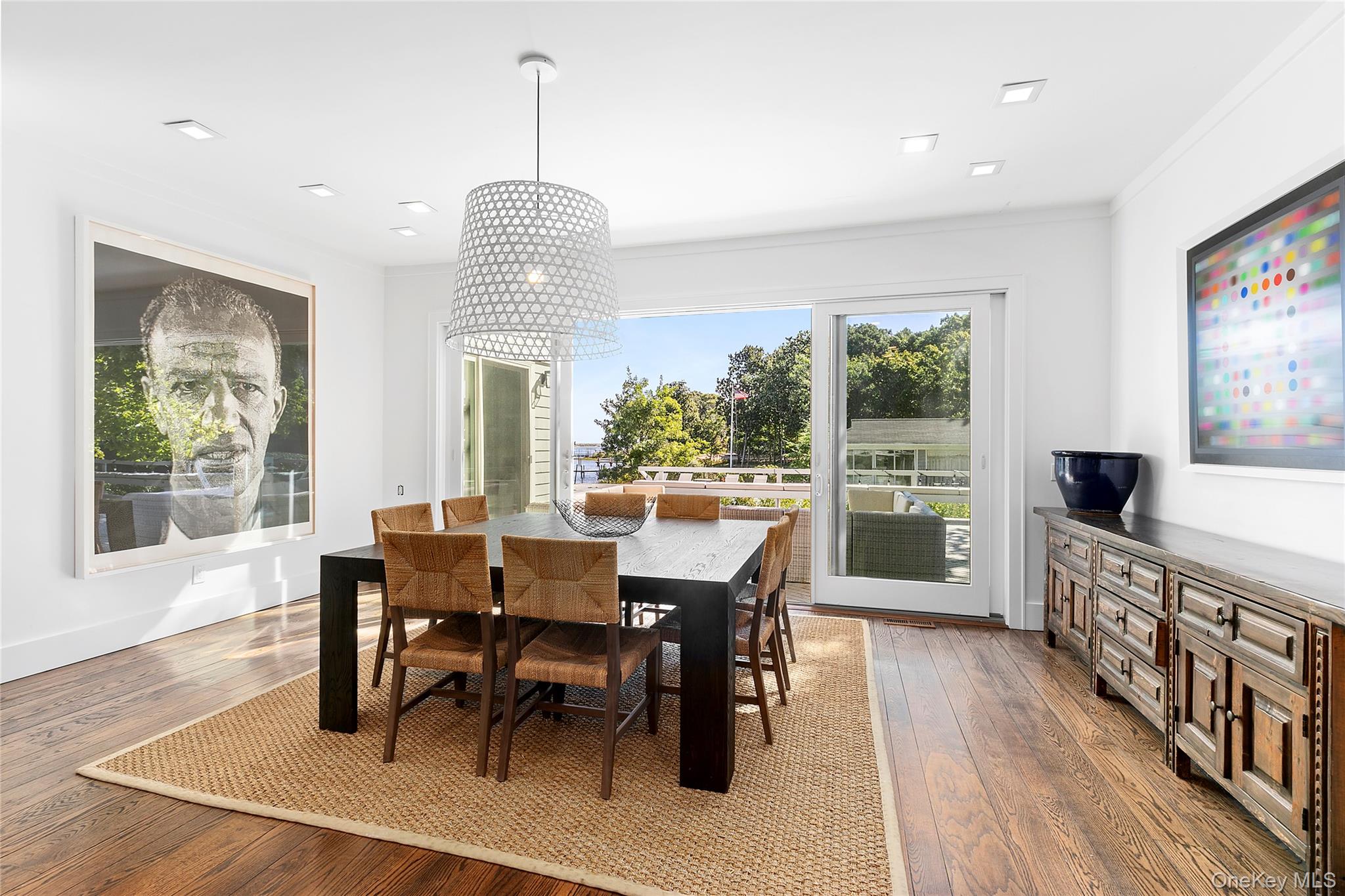 11 Bay Road Quogue, NY 11959 - Photo 9 of 41 a dining room with wooden floor a chandelier a wooden table and chairs
