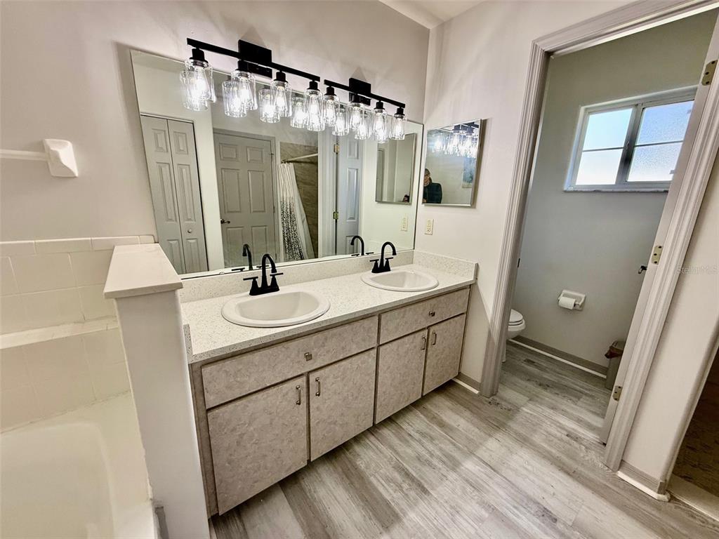 6008 Southwest 103rd Loop Ocala, FL 34476 - Photo 20 of 37 a bathroom with a double vanity sink mirror and shower