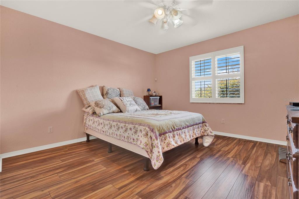 6008 Southwest 103rd Loop Ocala, FL 34476 - Photo 25 of 37 a bedroom with a bed and wooden floor