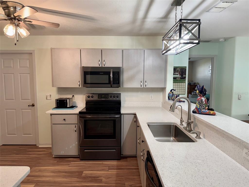 6008 Southwest 103rd Loop Ocala, FL 34476 - Photo 8 of 37 a kitchen with a sink a stove and cabinets