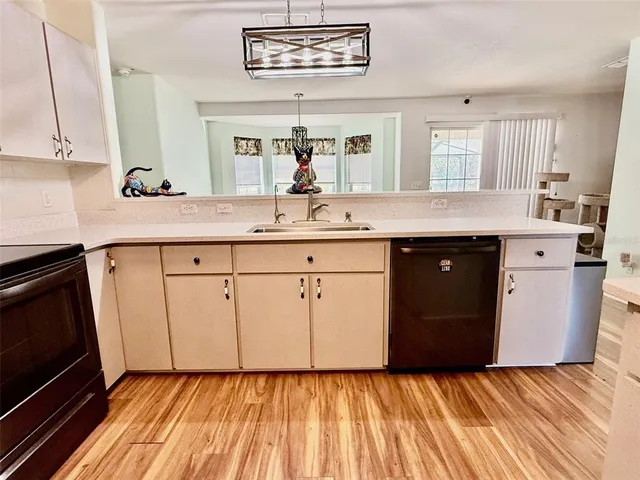 a kitchen with a sink window and cabinets