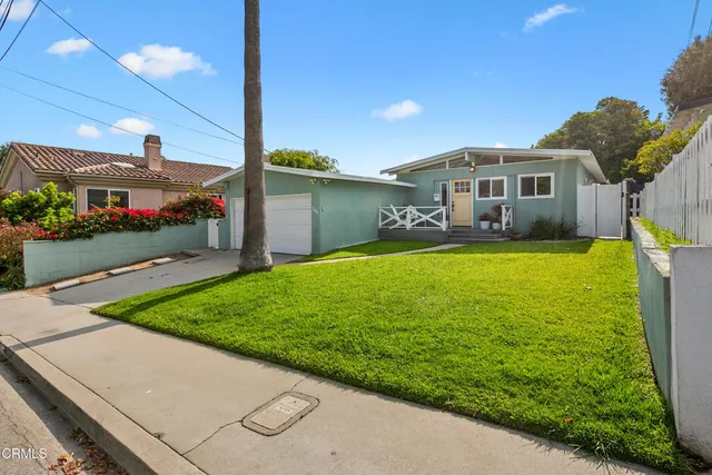 a view of a house with a yard and potted plants