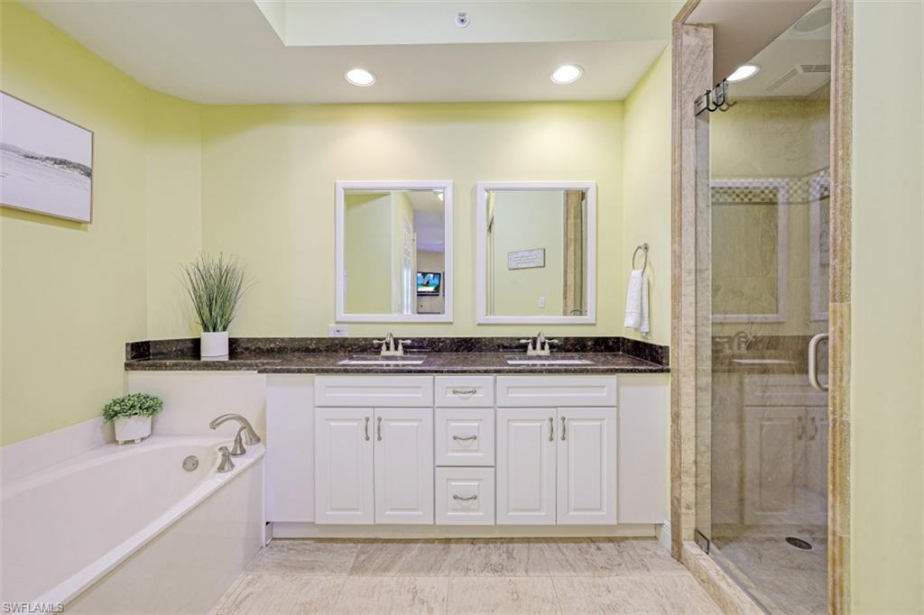 400 Flagship Drive, Unit 504 Naples, FL 34108 - Photo 12 of 38 Bathroom with a bath, a stall shower, and a sink