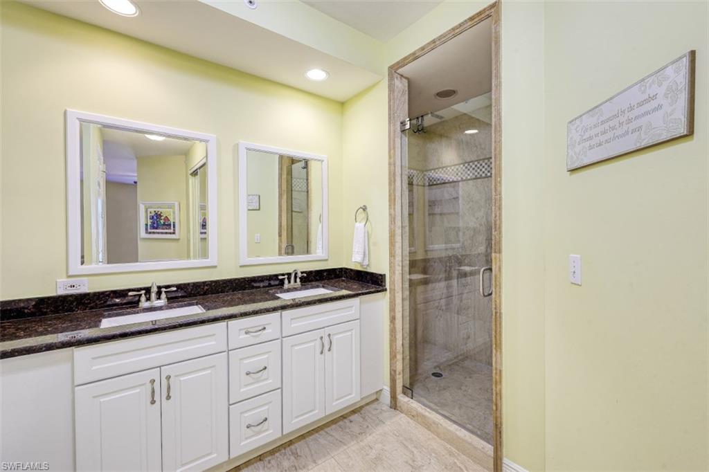 400 Flagship Drive, Unit 504 Naples, FL 34108 - Photo 13 of 38 Bathroom with double vanity, a shower stall, and a sink