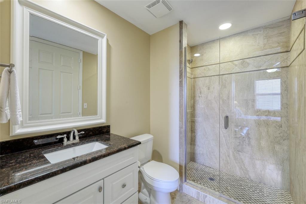 400 Flagship Drive, Unit 504 Naples, FL 34108 - Photo 16 of 38 Full bathroom with visible vents, a shower stall, toilet, and vanity
