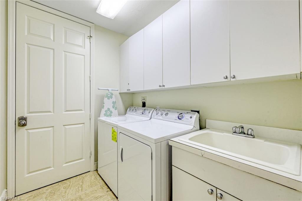 400 Flagship Drive, Unit 504 Naples, FL 34108 - Photo 18 of 38 Washroom featuring cabinet space, washer and dryer, and a sink