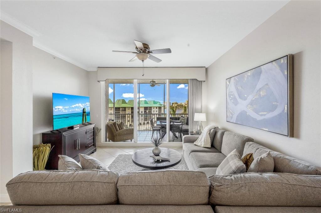 400 Flagship Drive, Unit 504 Naples, FL 34108 - Photo 21 of 38 Living area with tile patterned floors, crown molding, and a ceiling fan