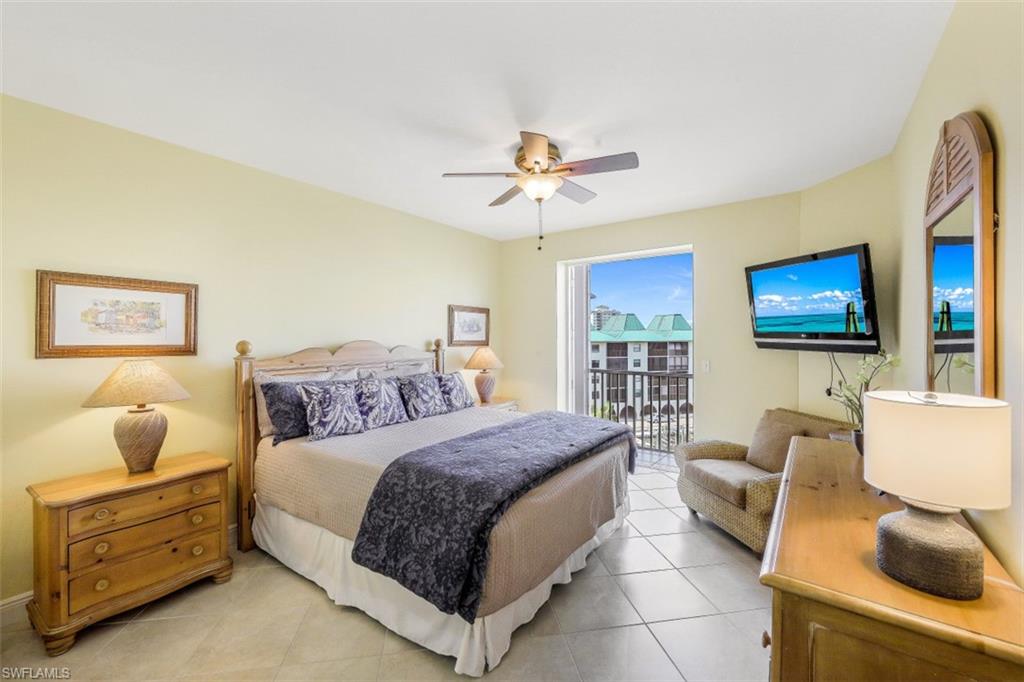 400 Flagship Drive, Unit 504 Naples, FL 34108 - Photo 23 of 38 Bedroom featuring access to exterior, light tile patterned flooring, and a ceiling fan