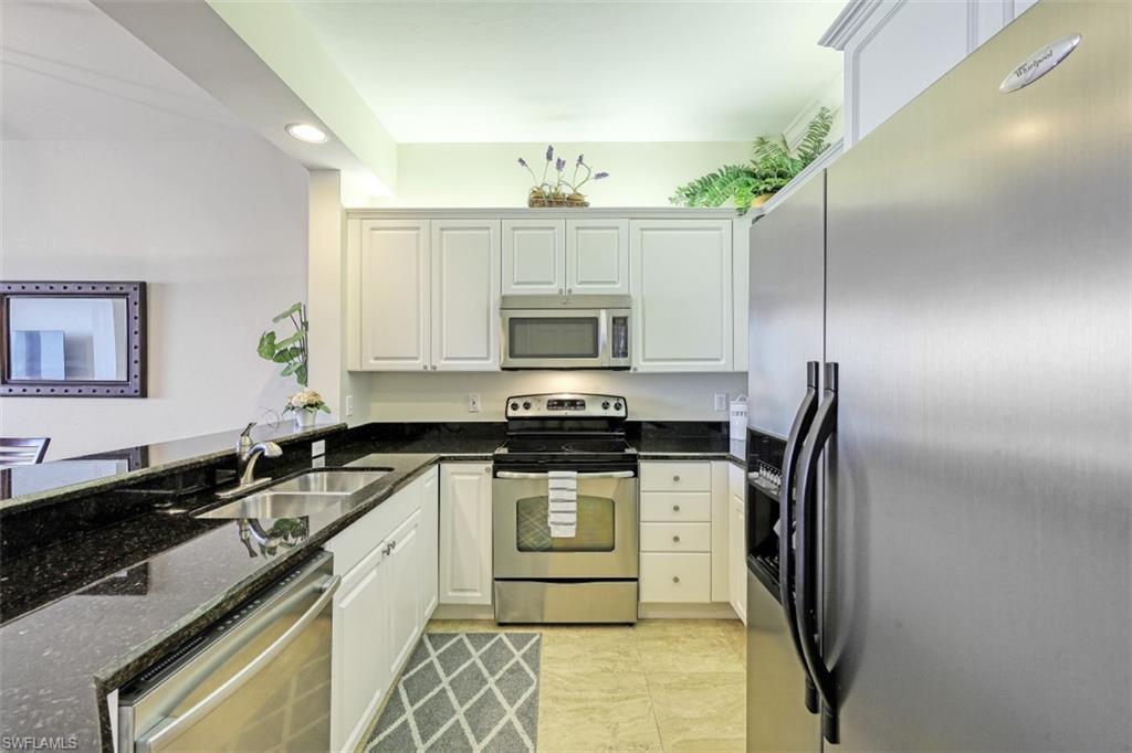 400 Flagship Drive, Unit 504 Naples, FL 34108 - Photo 5 of 38 Kitchen with recessed lighting, dark stone countertops, appliances with stainless steel finishes, white cabinets, and a sink