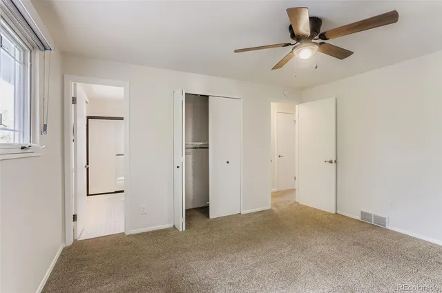 a view of a big room with chandelier fan and windows
