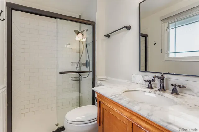 a bathroom with a granite countertop sink toilet and shower