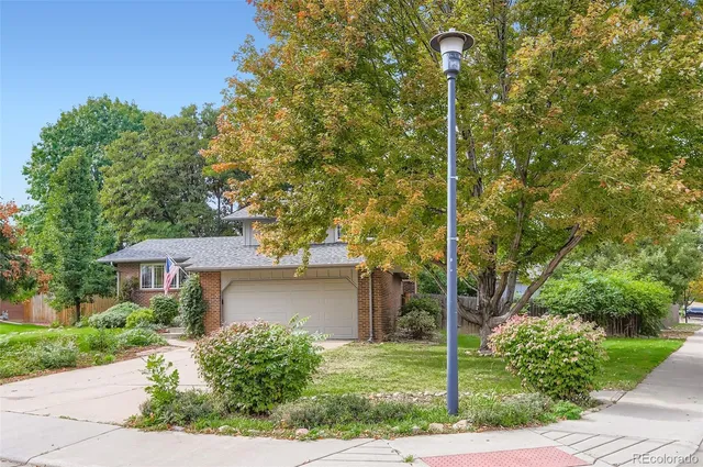 a front view of a house with a yard and trees
