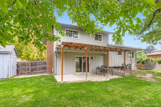 a view of a patio with table and chairs and a small yard